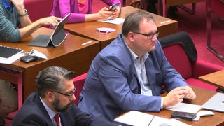 Zwei Politiker der Regierungsfraktionen in einer Diskussionsrunde.