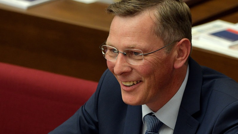 Frank Imhoff sitzt 2019 grinsend in der Bremer Bürgerschaft