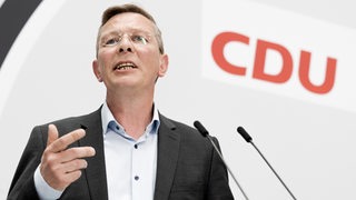 Frank Imhoff, Spitzenkandidat der CDU für die Bürgerschaftswahl in Bremen, steht auf einem Podium vor einem Mikrofon.