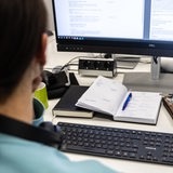 Eine Frau sitzt in einem Büro an einem PC und arbeitet (Symbolbild)