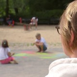 Eine Frau schaut auf einen Spielplatz