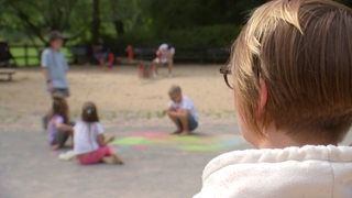 Eine Frau schaut auf einen Spielplatz