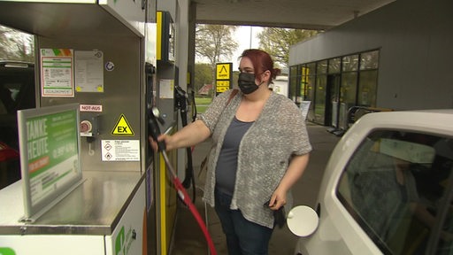 Eine Frau tankt Bio-CNG an einer Tankstelle.