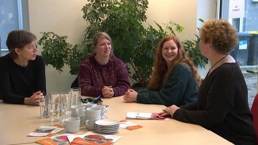 Vier Frauen am Tisch bei der Beratungsstelle "Arbeit im Fokus" für psychische Erkankte. 