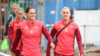 Die Nationalspielerinnen Giovanna Hoffmann und Laura Freigang laufen über das Gelände des SV Werder