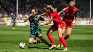 Werder-Stürmerin Larissa Mühlhaus stürzt im Zweikampf mit einer Freiburger Spielerin.