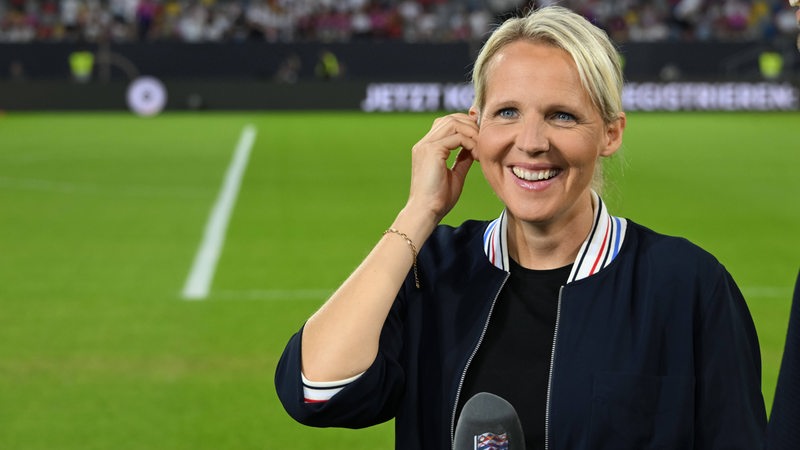 Die Fußball-Trainerin Friederike Kromp strahlt am Spielfeldrand des Nations-League-Spiels der DFB-Elf als TV-Expertin.