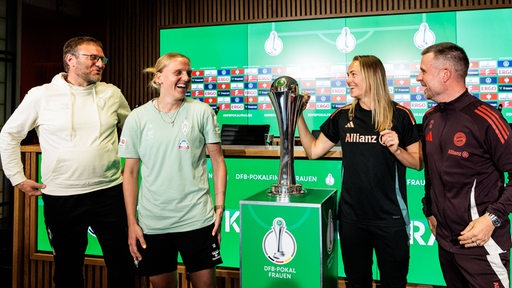 Werder-Trainer Thomas Horsch und Kapitänin Lina Hausicke stehen lachend nach der Pressekonferenz neben dem DFB-Pokal und scherzen mit Bayern-Spielerin Magdalena Eriksson und Trainer Alexander Straus.