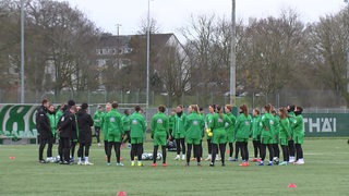 Die Werder-Frauen stehen bei einer Ansprache des Trainers im Kreis.