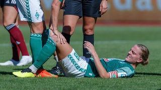 Werder-Kapitänin Lina Hausicke liegt im Spiel gegen Nürnberg verletzt auf dem Rücken mit schmerzverzerrtem Gesicht.