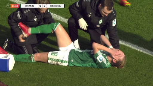 Werders Fußball-Kapitänin Lina Hausicke liegt verletzt auf dem Rasen und hält sich die Hände vors Gesicht, während ihr Knie behandelt wird.