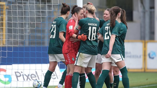 Werders Fußballerinnen umarmen ihre Torhüterin Livia Peng, die gegen Hoffenheim einen Elfmeter gehalten hat.