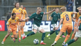 Werder-Kapitänin Lina Hausicke verteidigt den Ball im Spiel gegen mehrere Hoffenheimerinnen.