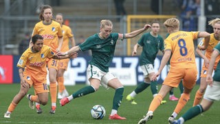 Werder-Kapitänin Lina Hausicke verteidigt den Ball im Spiel gegen mehrere Hoffenheimerinnen.