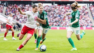 Carlotta Wamser im Zweikampf mit den Bremerinnen Saskia Matheis und Nina Lührßen.