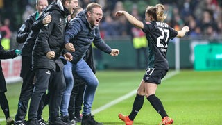 Werders Fußballerin Nina Lührßen rennt mit ausgebreiteten Armen nach ihrem Tor gegen Freiburg auf Trainer Thomas Horsch an der Seitenline zu, der ebenfalls jubelt.