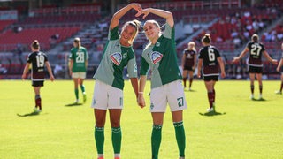 Die Werder Fußballerinnen Maja Sternad und Nina Lührßen formen nach dem Tor gegen Nürnberg mit ihren Armen ein Herz auf dem Platz.