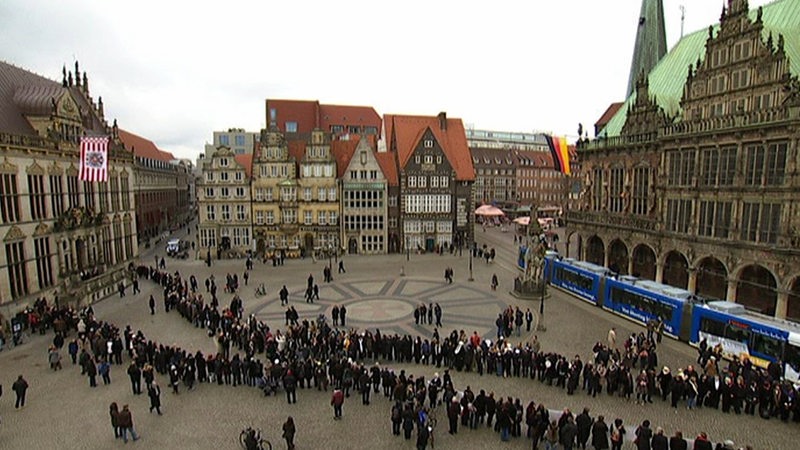 Frauen stehen Spalier über den Bremer Marktplatz.
