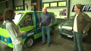 Reporter Freddy Radeke und Ansgar Langhorst stehen mit einem weiteren Mann vor einerm grünen Fiat-Auto. Das Auto war mal das Papa Mobil und gehörte dem Papst.