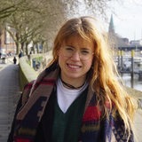 Eine Frau steht an der Bremer Schlachte vor der Weser.