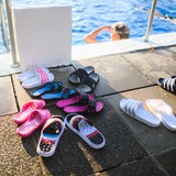 Badelatschen von Frühschwimmern stehen am frühen Morgen im Freibad
