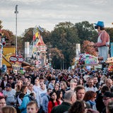 Besucher gehen zwischen Ständen und Fahrgeschäften auf dem 989. Freimarkt in Bremen. 