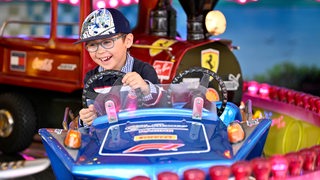 Ein kleiner Junge in einem Kinderkarussell