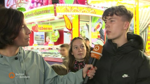 Die Reporterin Anna Berkhout interviewt auf dem Freimarkt einen Jugendlichen.