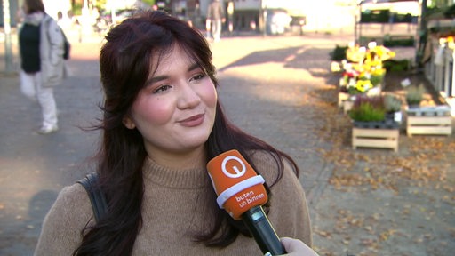 Eine junge Frau im Interview von buten un binnen.