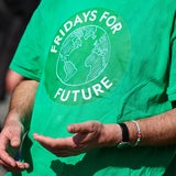 Ein Teilnehmer einer Fridays-for-Future-Demonstration trägt ein grünes T-Shirt der Organisation. 