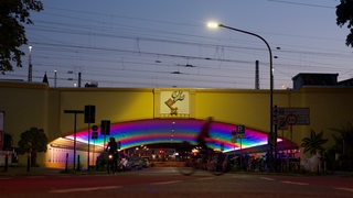 In Regenbogenfarben ausgeleuchteter Tunnel mit großem Emblem aus Bremer Schlüssel und Taube