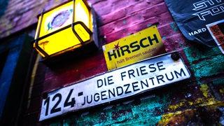 An einer Wand ist ein Schild mit der Aufschrift "Die Friese Jugendzentrum" zu sehen.