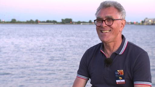 Der Veranstalter vom Festival Maritim Fritz Rapp bei einem Interview vor einem Fluss. 