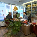 Ein Mann und eine Frau sitzen im Reisebüro.
