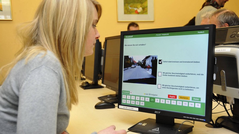 Eine Frau macht an einem Computer einen Führerschein-Test