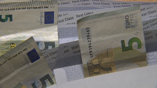 Mehrere Briefumschläge, aus denen jeweils ein fünf Euro Schein heraus guckt.