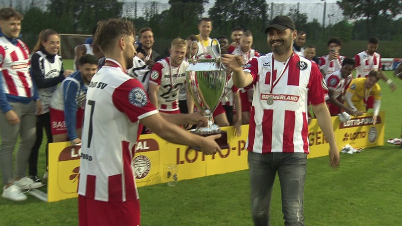 Spieler des Bremer SV feiern den Pokal-Sieg auf dem Spielfeld.