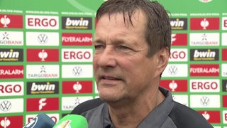 BSV-Trainer Torsten Gütschow steht nach dem Pokalspiel vor einer Werbewand beim Interview.