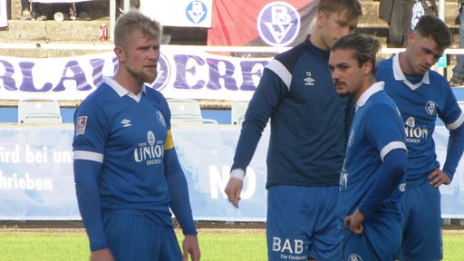 Mehrere Fußballspieler des Bremer SV stehen nach einer Niederlage auf dem Spielfeld.