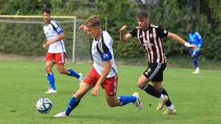 Beherzter Zweikampf zwischen einem Regionalliga-Fußballer des Hamburger SV und dem Bremer SV.