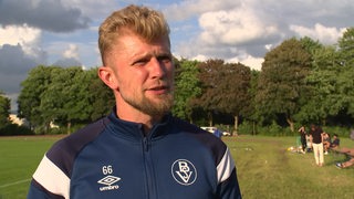 Der neue Trainer des Bremer SV Sebastian Kmiec am Rande des Trainingsplatzes beim TV-Interview.