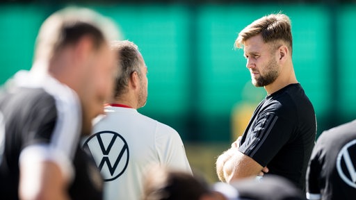 Fußball-Nationalspieler Niclas Füllkrug am Rande des Trainings im Gespräch mit Bundestrainer Hansi Flick.