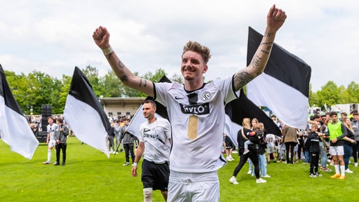 Fußball-Spieler Nick Woltemade reißt im Trikot von Drittligist Elversberg jubelnd die Arme hoch.