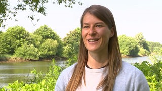 Fußball-Trainerin Marie-Louise Eta lächelt bei einem Interview am Weser-Ufer.