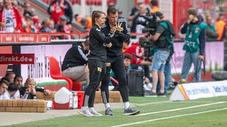 Marie-Louise Eta und Marco Grote beraten sich am Spielfeldrand. 