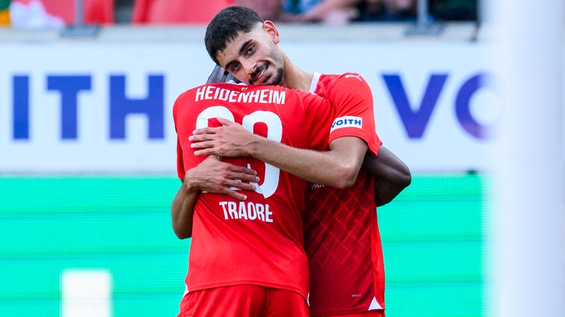 Werders Leihspieler Eren Dinkci umarmt seinen Mitspieler nach einem Treffer für Heidenheim.