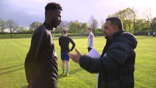 Der Fußballer Muhammed Sanneh von der SV Hemelingen im Gespräch mit Trainer Günther Tuncel.