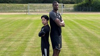 Die Hemelinger Spieler Shizu Yohena (l.) und Isa Drammeh (r.) stehen nebeinander. Yohena ist 1,58 Meter groß, Drammeh 40 Zentimeter größer.