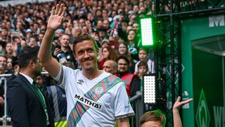 Ex-Werder-Profi Max Kruse winkt den Fans im Weser-Stadion zu, als er zum Abschiedsspiel von Claudio Pizarro einläuft.