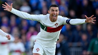 Portugals Fußball-Star Cristiano Ronaldo strahlt und feiert mit weit ausgebreiteten Armen seinen Treffer in der Nationalmannschaft.
